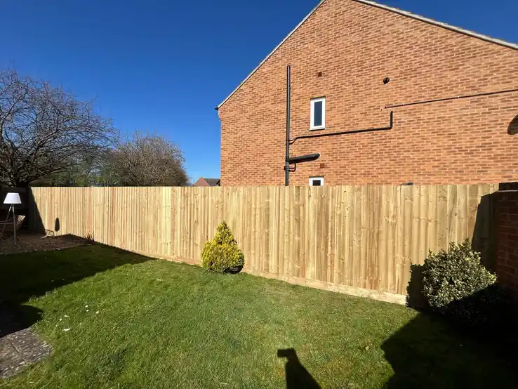 High-quality pressure-treated wooden fence providing privacy and security while enhancing the garden's appearance.