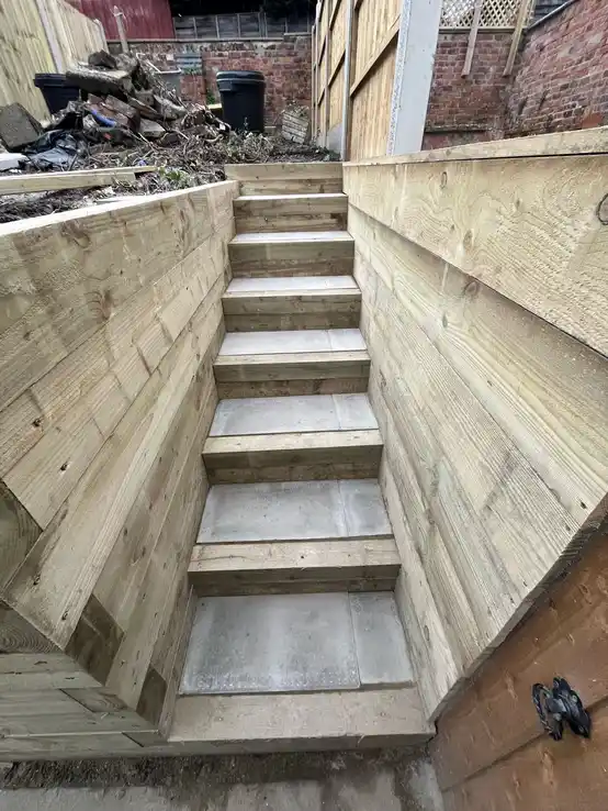 Expertly crafted wooden steps with stone treads, providing both functionality and aesthetic appeal to navigate different garden levels.