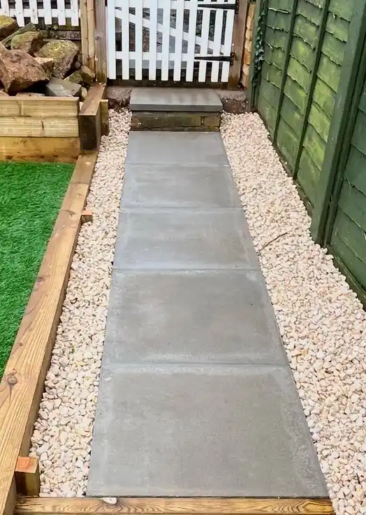 Elegant garden pathway using concrete slabs surrounded by decorative gravel, creating a practical and visually appealing garden feature.