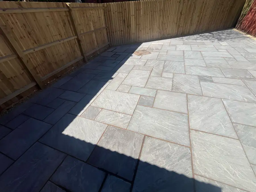Custom patio with contrasting light and dark stone pavers, creating a modern and elegant outdoor space.